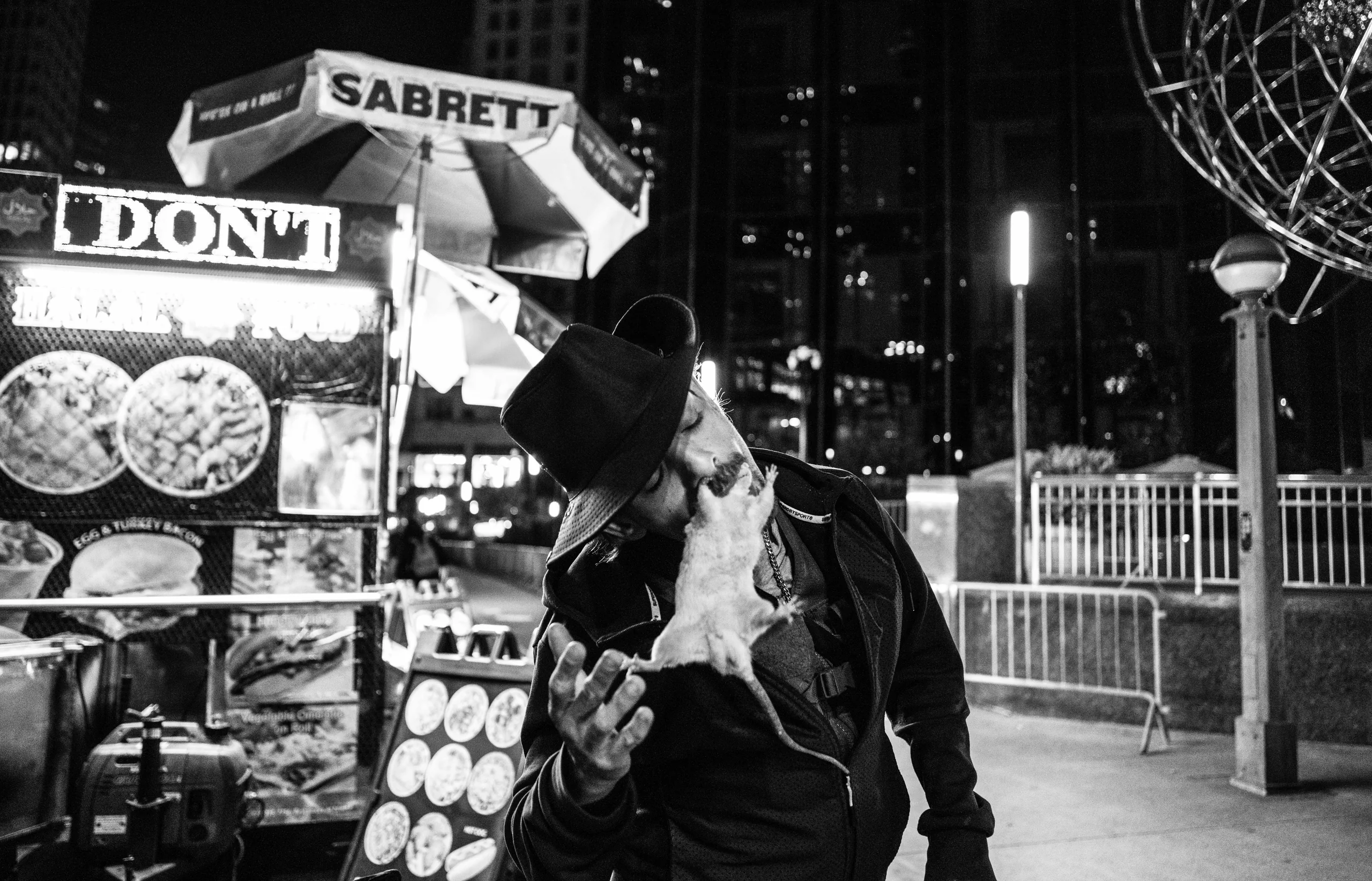 Man holds a rat in his mouth in New York City